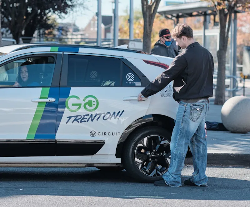 Young man getting into a GOTrenton! rideshare electric vehicle
