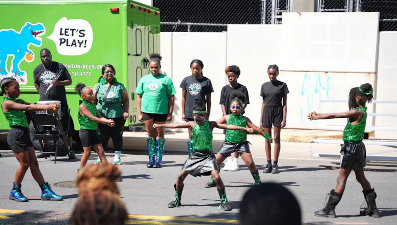 Young kids putting on a dance performance in front of a T-Recs mobile recreation van